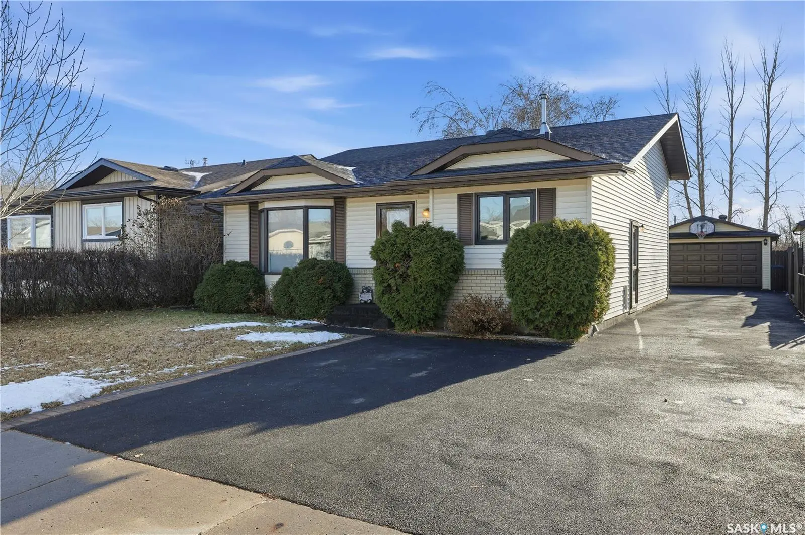 Exterior photo of 235 Sherry Crescent Saskatoon SK showing split-level family home with attached garage and yard.